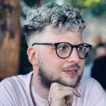 Portrait of Tizian Adam, a software engineer and technical writer, smiling at the camera
